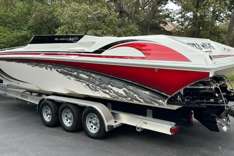 Slide: The Image of 2002 Fountain 38 Lightning speedboat with red and white design on a trailer. - 8