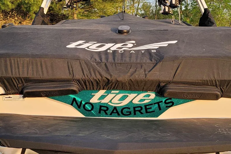 Slide: The Image of 2022 Tigé Z1 boat with cover, featuring "No Ragrets" text on the back. - 11