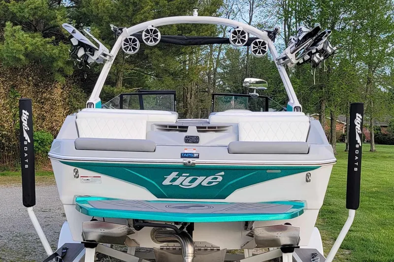 Slide: The Image of 2022 Tigé Z1 boat with wakeboard racks and speakers, parked on grass. - 15