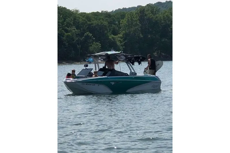 Slide: The Image of 2022 Tigé Z1 boat on a lake with people enjoying water activities. - 16