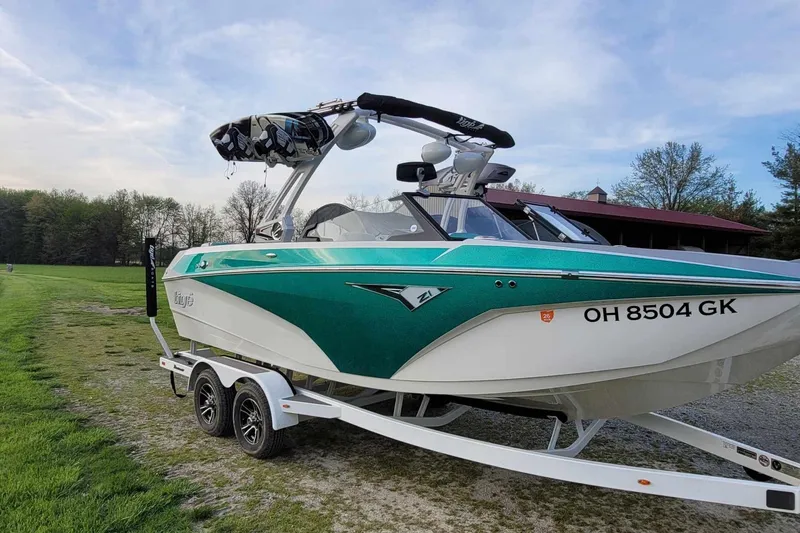 Slide: The Image of 2022 Tigé Z1 boat on trailer, green and white design, parked on grass. - 3