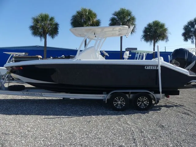 Slide: The Image of 2018 Carrera Sport Fishing boat on trailer, palm trees in background. - 6