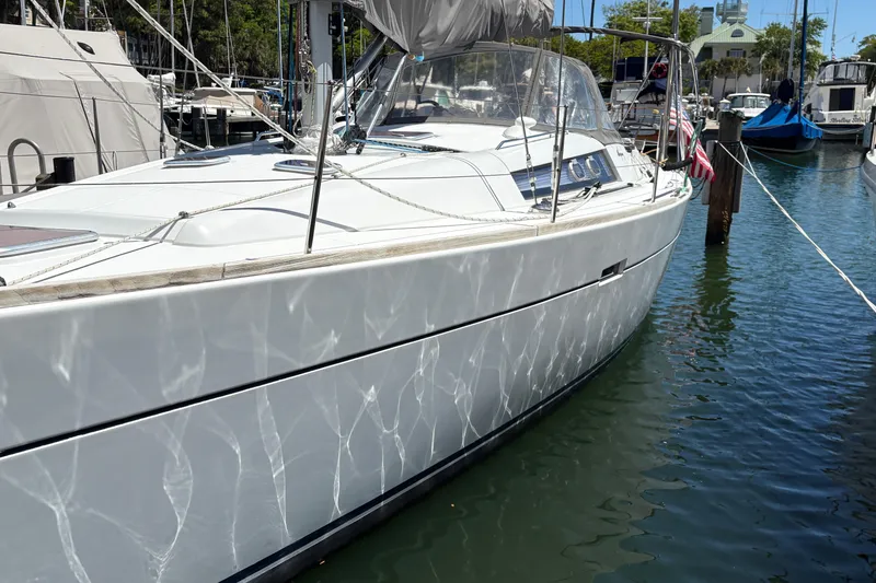 Slide: The Image of 2008 Wauquiez Centurion 40s sailboat docked in a marina, reflecting sunlight on water. - 5