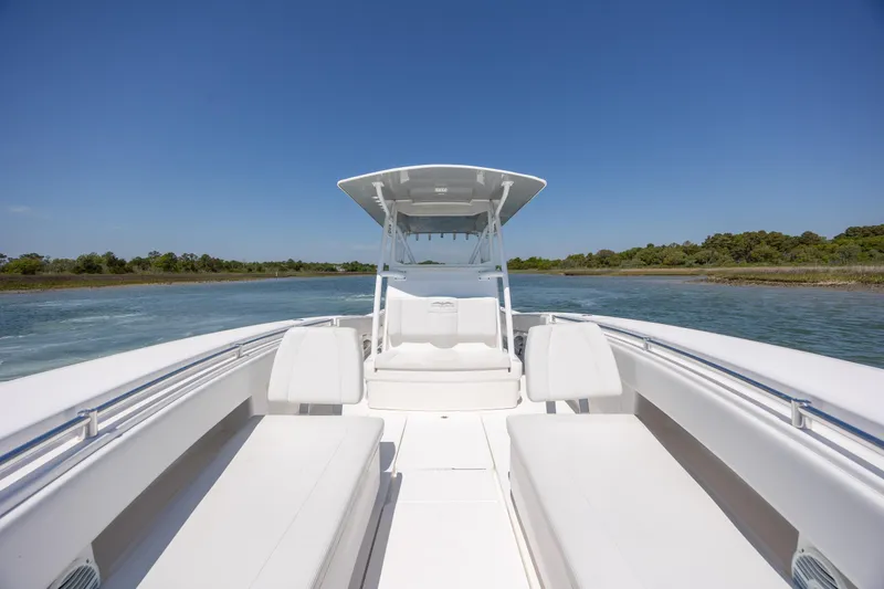 Slide: The Image of 2019 Invincible 36 Open Fisherman boat on calm water, featuring spacious seating and sleek design. - 23