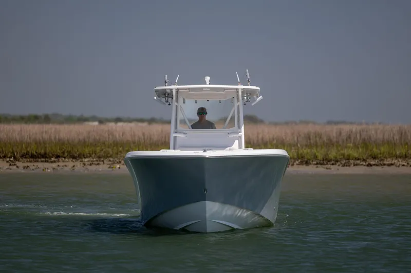 Slide: The Image of 2019 Invincible 36 Open Fisherman boat cruising on calm water near shoreline. - 4