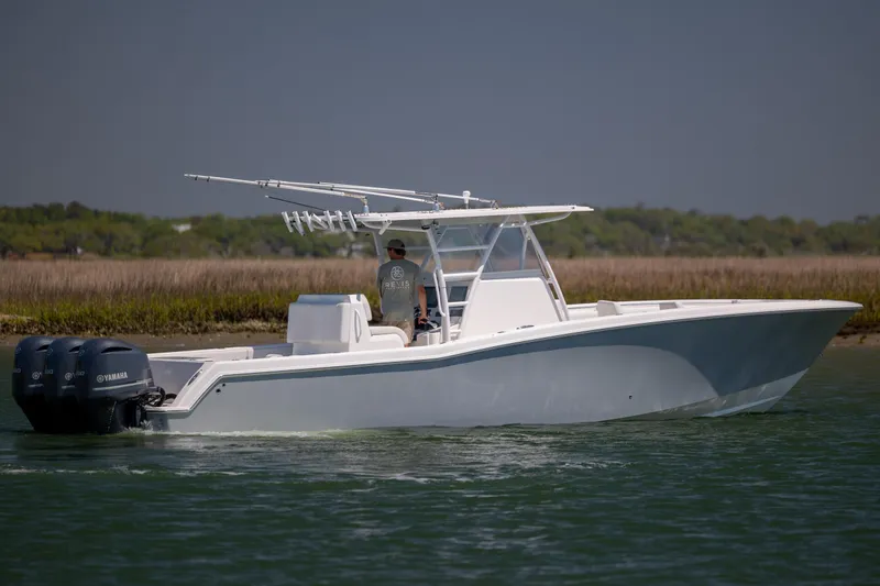 Slide: The Image of 2019 Invincible 36 Open Fisherman boat with triple Yamaha engines on calm water. - 6