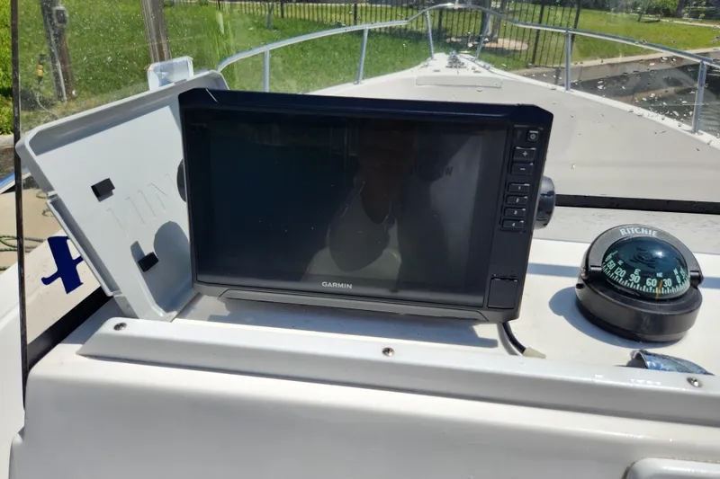 Slide: The Image of Garmin GPS and Ritchie compass on 2001 Cobia 234 Center Console boat dashboard. - 19