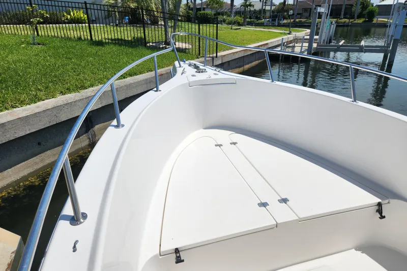 Slide: The Image of 2001 Cobia 234 Center Console boat docked by a grassy waterfront. - 21