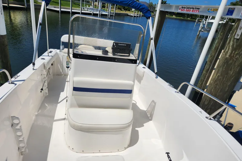 Slide: The Image of 2001 Cobia 234 Center Console boat docked at marina, featuring spacious seating and clear windshield. - 4