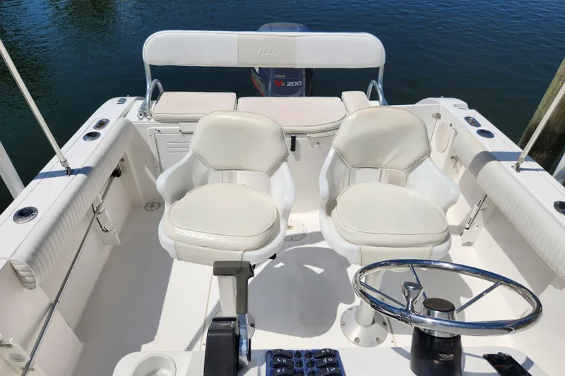 Slide: The Image of 2001 Cobia 234 Center Console boat interior with dual seats and steering wheel. - 7