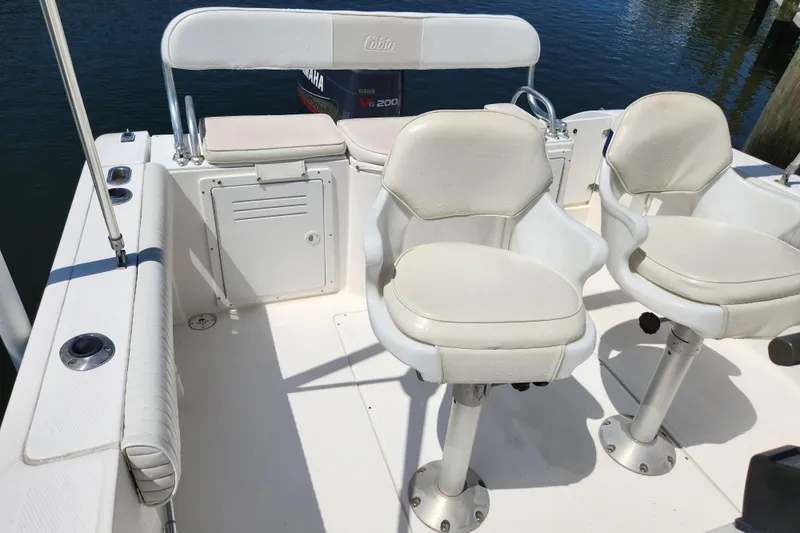 Slide: The Image of 2001 Cobia 234 Center Console boat interior with white seating and Yamaha engine. - 8