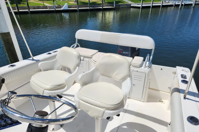 Slide: The Image of 2001 Cobia 234 Center Console boat interior with helm and seating by the water. - 9