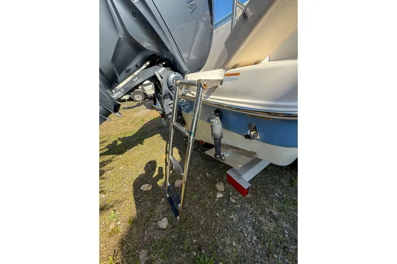 Slide: The Image of 2022 Robalo R227 Dual Console boat with ladder and motor detail. - 10