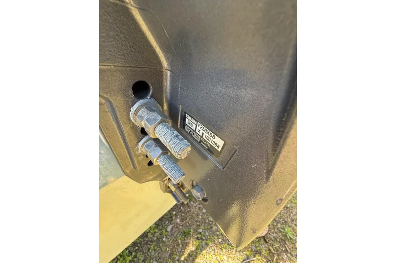 Slide: The Image of Close-up of 2022 Robalo R227 Dual Console boat engine bolts and label. - 13