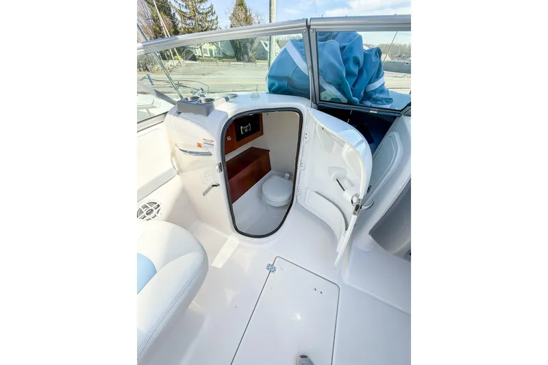 Slide: The Image of 2022 Robalo R227 Dual Console boat interior with open cabin door and seating. - 15