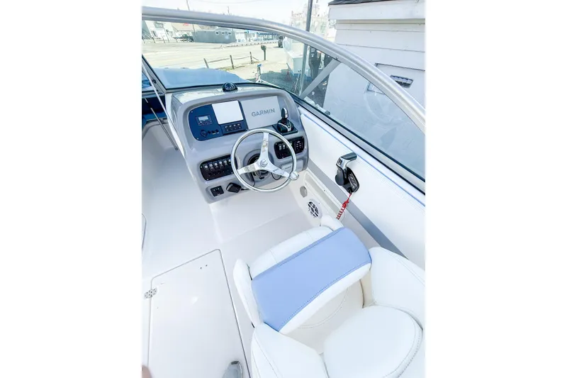 Slide: The Image of 2022 Robalo R227 Dual Console boat cockpit with Garmin navigation system and sleek steering wheel. - 16