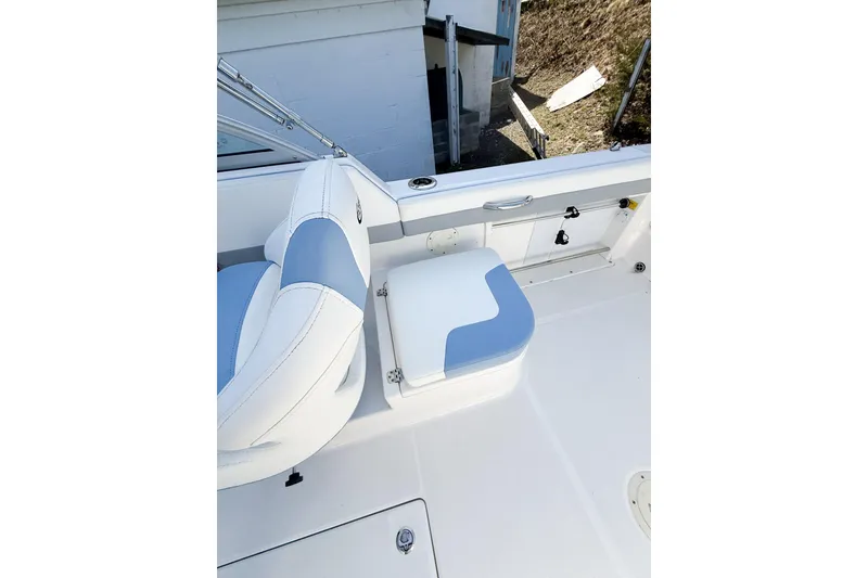 Slide: The Image of 2022 Robalo R227 Dual Console boat interior with white and blue seating. - 18