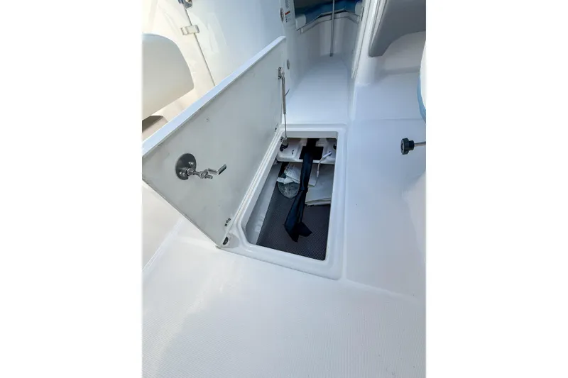Slide: The Image of 2022 Robalo R227 Dual Console boat storage compartment open on deck. - 24
