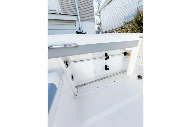 Slide: The Image of 2022 Robalo R227 Dual Console boat interior, featuring sleek storage compartment and stainless steel railing. - 30