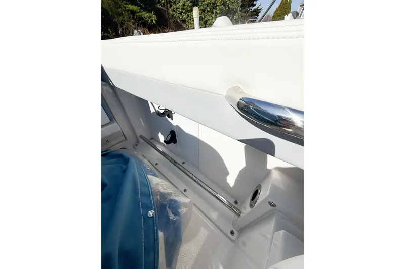Slide: The Image of Interior view of 2022 Robalo R227 Dual Console boat, featuring white seating and chrome details. - 32