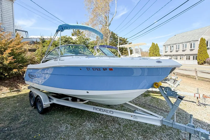 Slide: The Image of 2022 Robalo R227 Dual Console boat on trailer, parked outdoors. - 4
