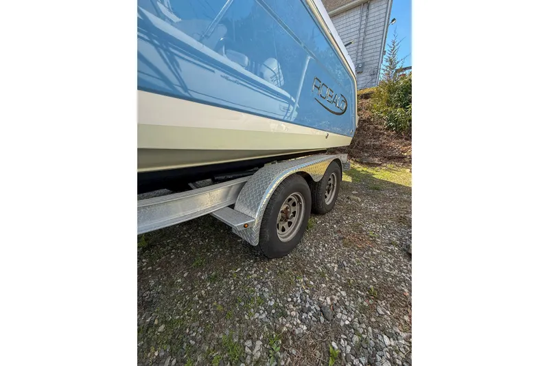 Slide: The Image of 2022 Robalo R227 Dual Console boat on trailer, parked on gravel. - 9
