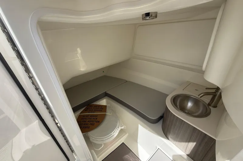 Slide: The Image of Interior of 2026 Sea Ray SDX 250 boat featuring compact cabin with sink and seating. - 18