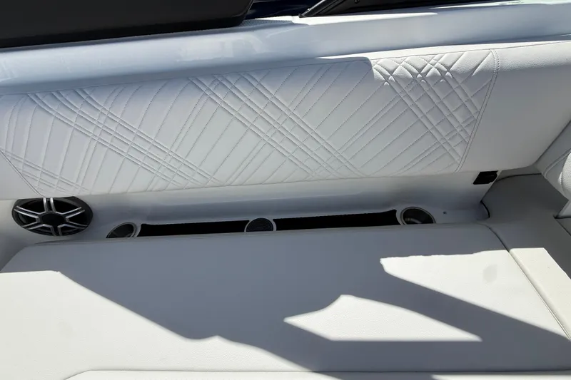 Slide: The Image of Interior of 2026 Sea Ray SDX 250 boat with white quilted upholstery and speaker. - 9