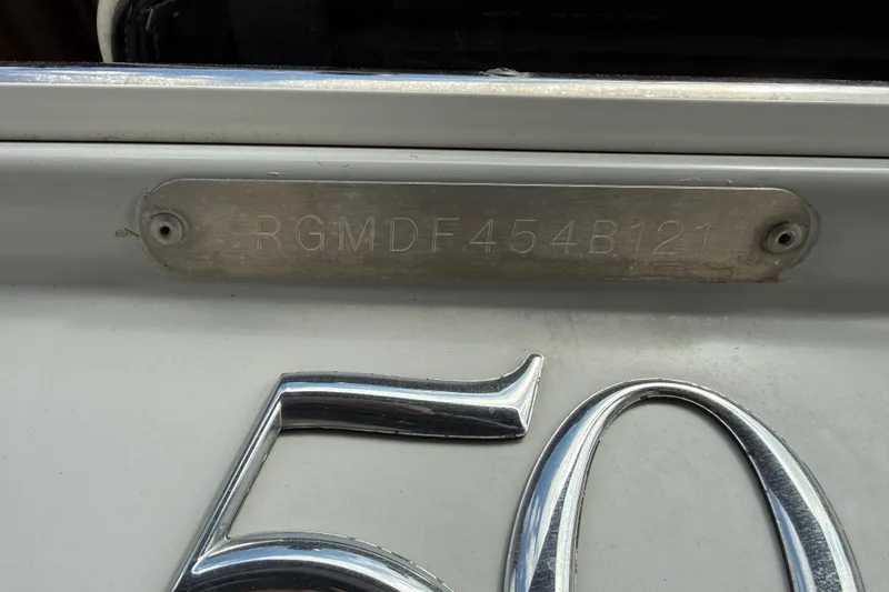 Slide: The Image of 2021 Regal LS4 Surf boat's stern with propeller and outdrive, parked on gravel. - 16