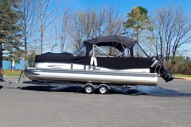 The Image of 2021 Premier 250 Grand Majestic pontoon boat on trailer, parked outdoors. - 1