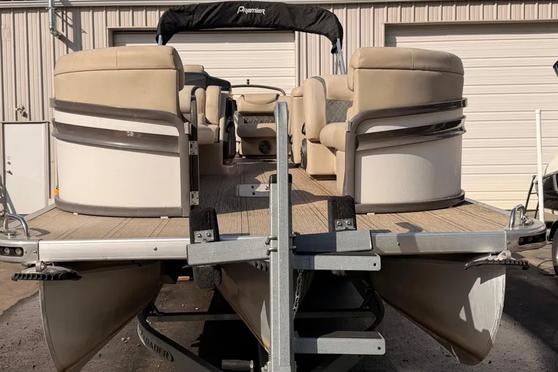 Slide: The Image of 2021 Premier 250 Grand Majestic pontoon boat on trailer, beige seating, docked outdoors. - 3