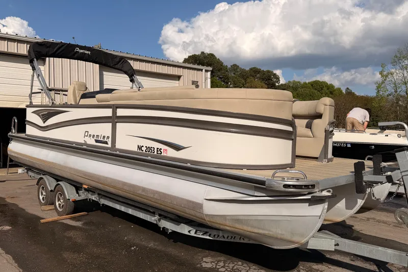 Slide: The Image of 2021 Premier 250 Grand Majestic pontoon boat on trailer, parked outdoors. - 4