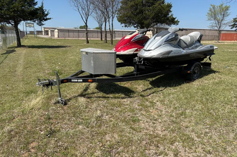 Slide: The Image of Two Yamaha WaveRunner FX Cruiser SHO jet skis on a trailer, parked on grass. - 4
