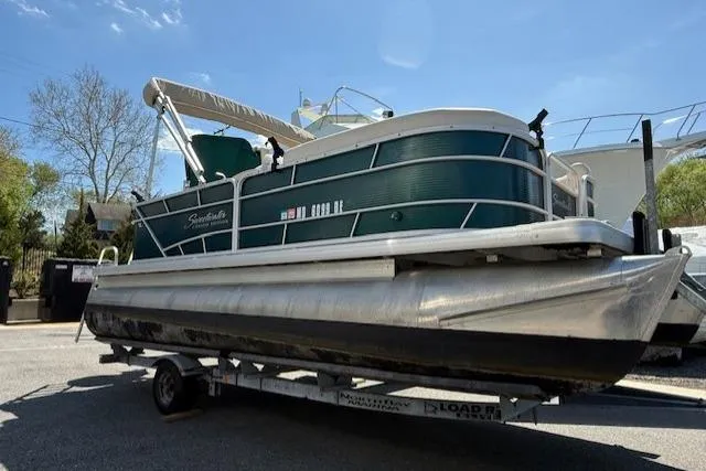 The Image of 2015 Sweetwater 2086 BW pontoon boat on trailer, parked outdoors under clear sky. - 0