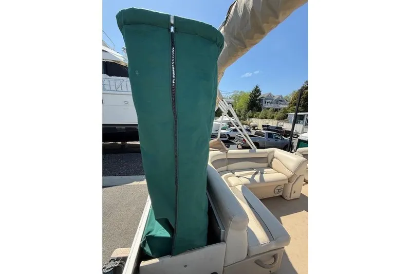 Slide: The Image of 2015 Sweetwater 2086 BW boat with green cover and beige seating. - 10