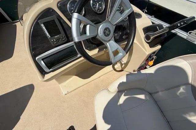 Slide: The Image of Steering console of a 2015 Sweetwater 2086 BW boat with beige seating. - 12