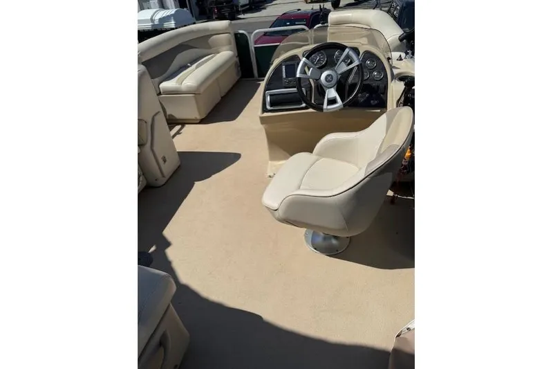 Slide: The Image of Interior of a 2015 Sweetwater 2086 BW boat with beige seating and steering console. - 13