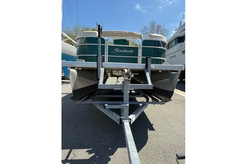 Slide: The Image of 2015 Sweetwater 2086 BW pontoon boat on trailer, parked outdoors. - 2