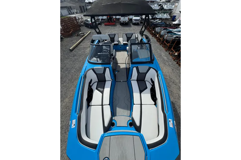 Slide: The Image of 2022 Yamaha Boats 255XD, blue and white interior, docked in a marina. - 11