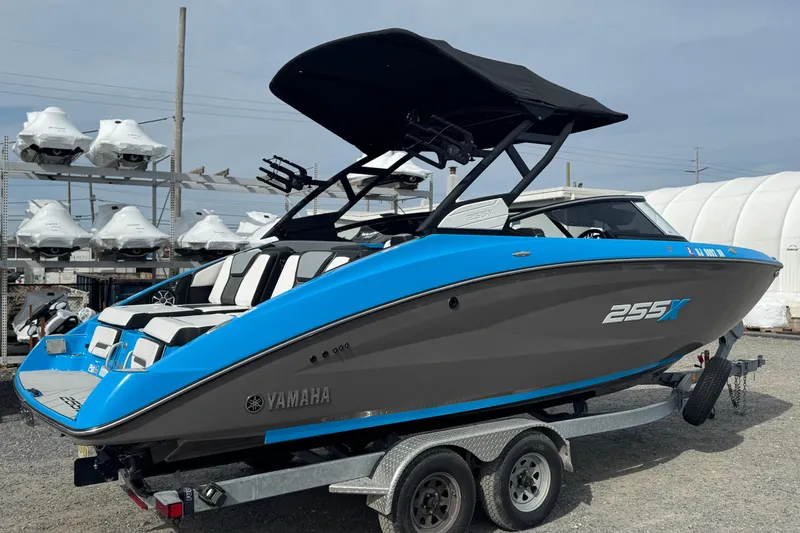 Slide: The Image of 2022 Yamaha Boats 255XD in blue and gray on a trailer, displayed outdoors. - 2