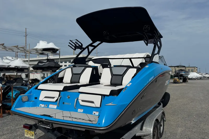 Slide: The Image of 2022 Yamaha Boats 255XD in blue, displayed on a trailer at a marina. - 7