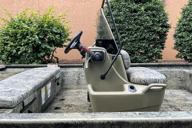 Slide: The Image of 2026 Tracker Grizzly 1860 CC boat interior with steering console and camouflage seating. - 4