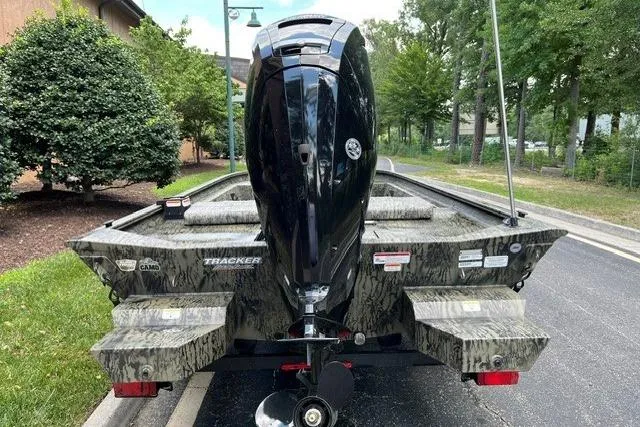 Slide: The Image of 2026 Tracker Grizzly 1860 CC boat with camo design and powerful outboard motor. - 3