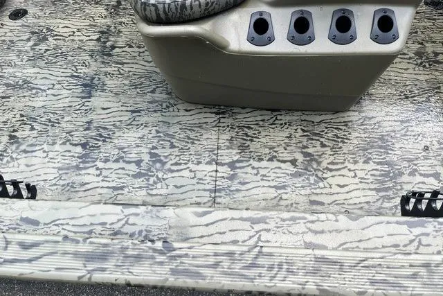 Slide: The Image of 2026 Tracker Grizzly 1860 CC boat interior with camo pattern and rod holders. - 7
