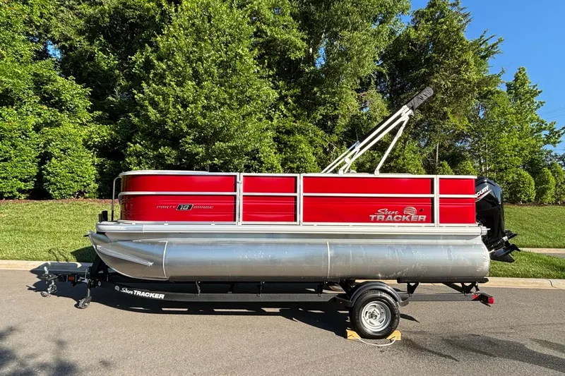 The Image of 2026 Sun Tracker Party Barge 18 DLX pontoon boat on trailer, parked on a sunny day. - 0