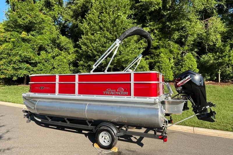 Slide: The Image of 2026 Sun Tracker Party Barge 18 DLX pontoon boat with Mercury outboard motor on trailer. - 3