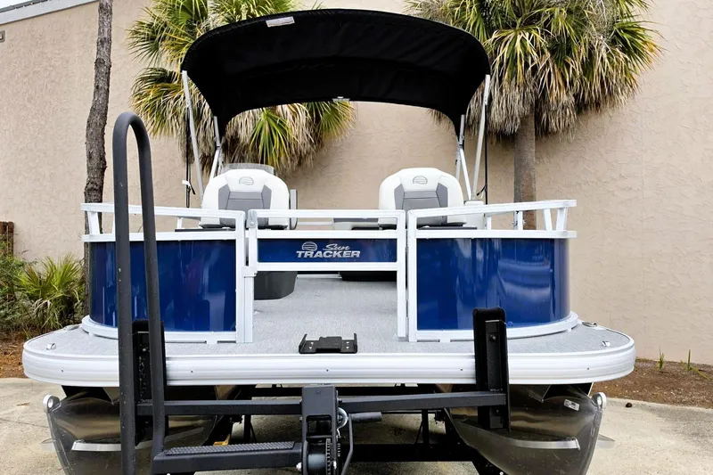 Slide: The Image of 2026 Sun Tracker Bass Buggy 16 XL Select pontoon boat with canopy, parked outdoors. - 4