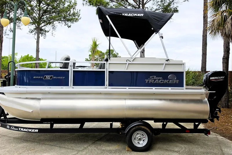 Slide: The Image of 2026 Sun Tracker Bass Buggy 16 XL Select pontoon boat on trailer, side view. - 5