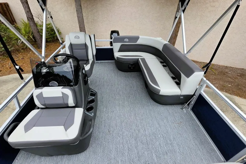 Slide: The Image of 2026 Sun Tracker Bass Buggy 16 XL Select pontoon boat interior with gray seating and helm. - 9
