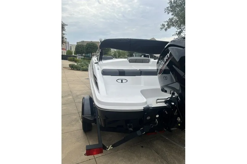 Slide: The Image of 2026 Tahoe T16 boat with Mercury engine, parked on a trailer, rear view. - 3